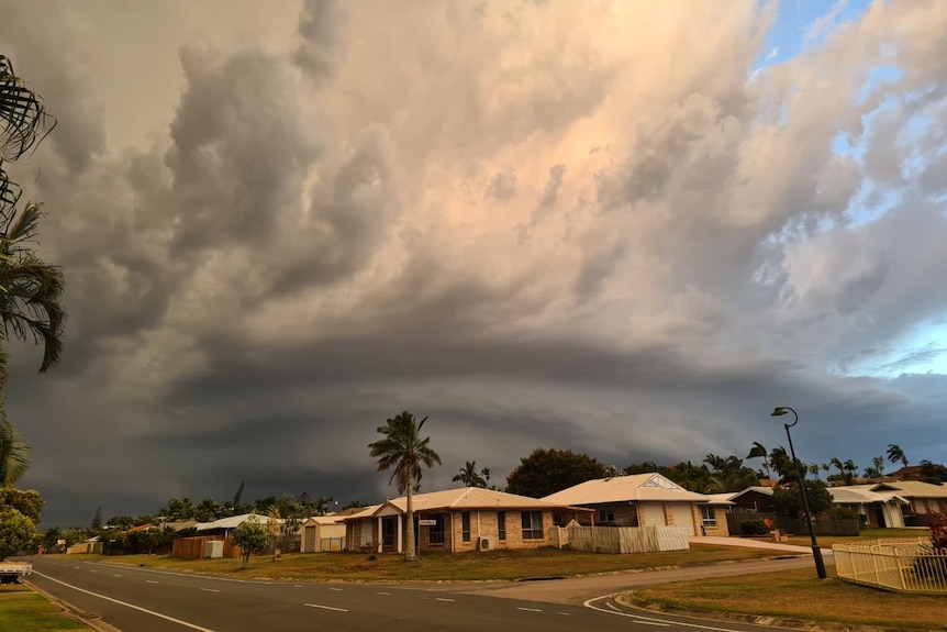 a street with a dark grey cloud overhead