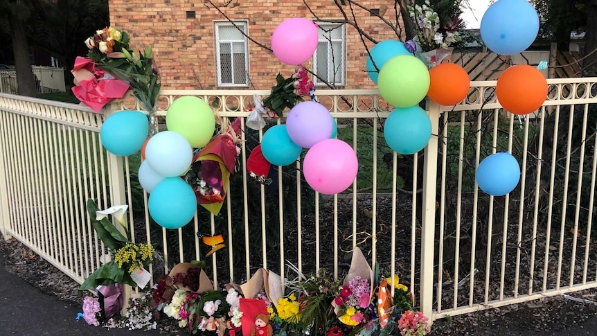 flowers on a fence outside housing commission flats in North Fitzroy following a fatal fire