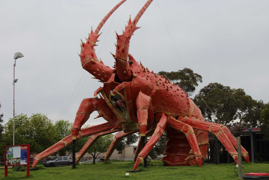 Larry the Lobster on the patch of grass by the highway where he lives.