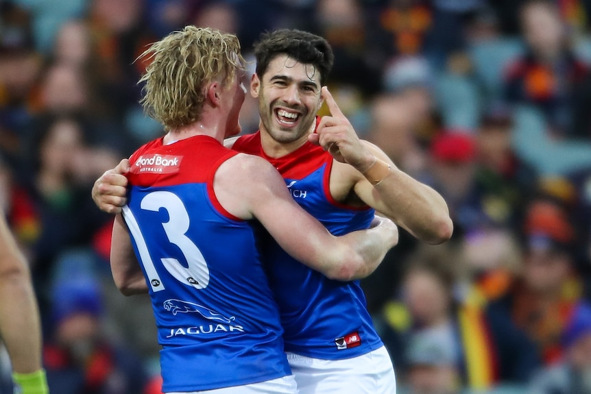 Christian Petracca smiles and holds his finger up while hugging Clayton Oliver