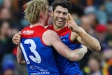 Christian Petracca smiles and holds his finger up while hugging Clayton Oliver