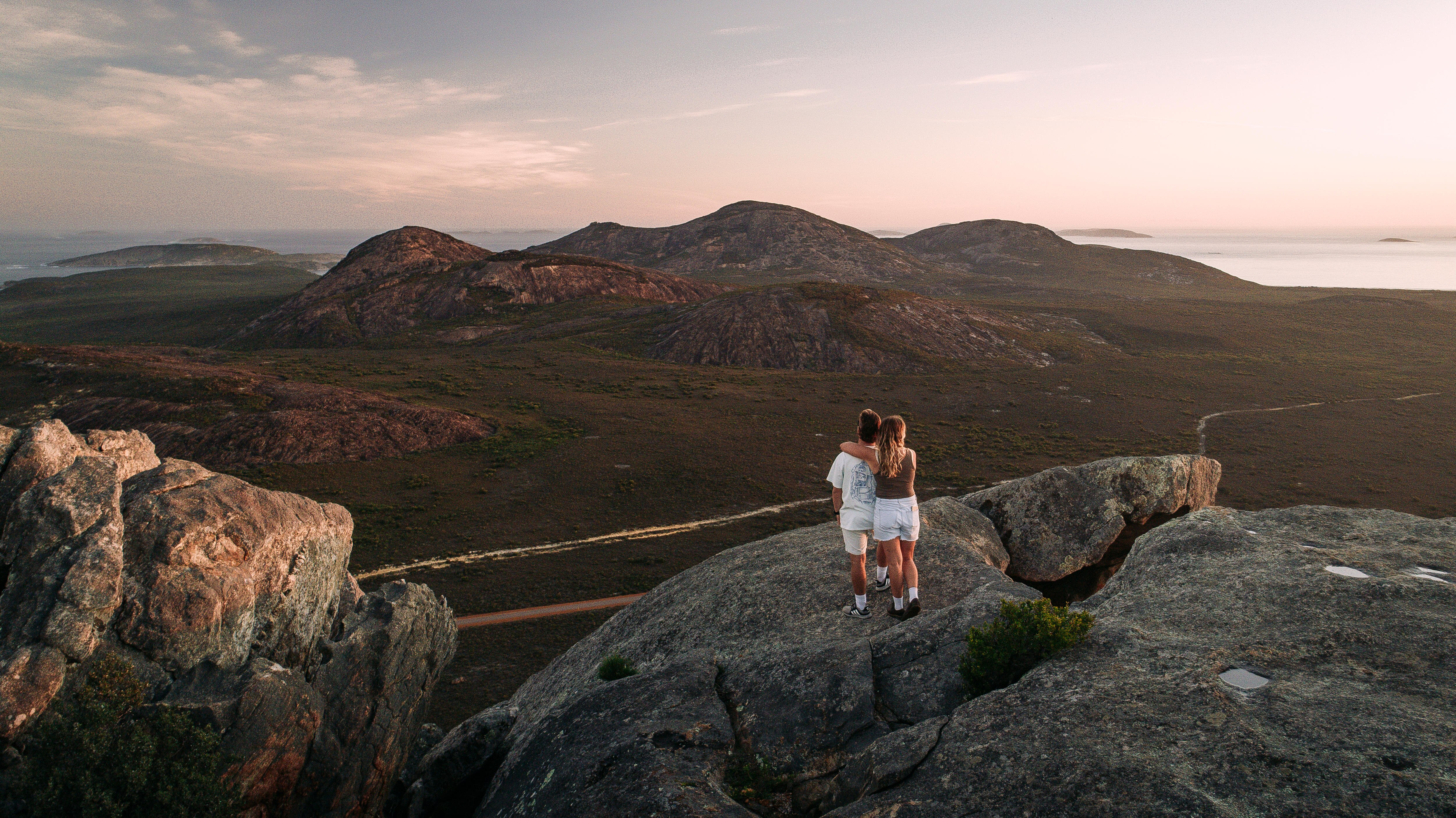 A couple stand on top of a mountain
