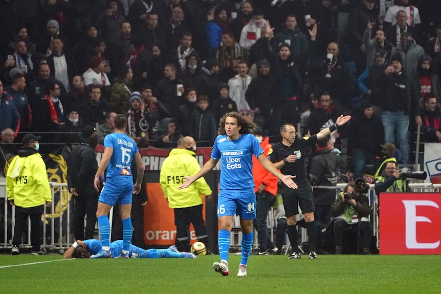 Marseille's Matteo Guendouzi gestures as his teammate Dimitri Payet lies on the ground