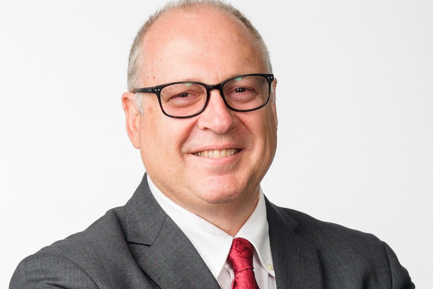 A man with glasses wearing a suit.