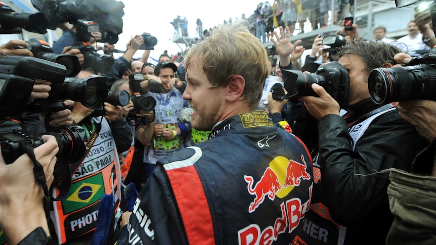 Sebastian Vettel has become the youngest-ever F1 triple-champion after coming sixth in Brazil.