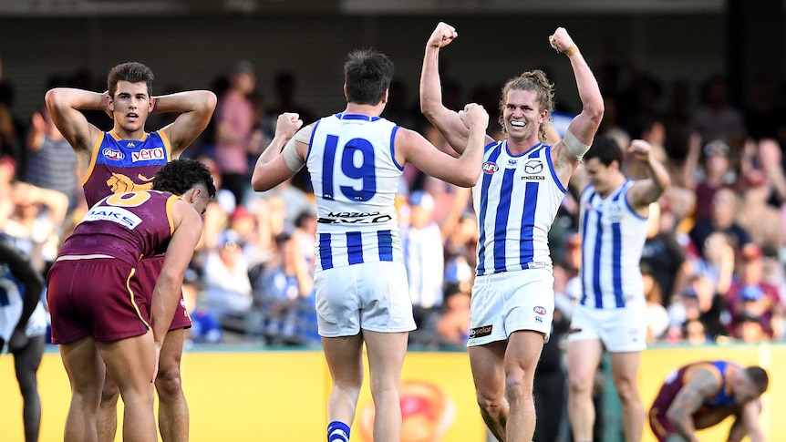 Jed Anderson of North Melbourne (R) celebrate the Kangaroos' win over Brisbane at the Gabba.