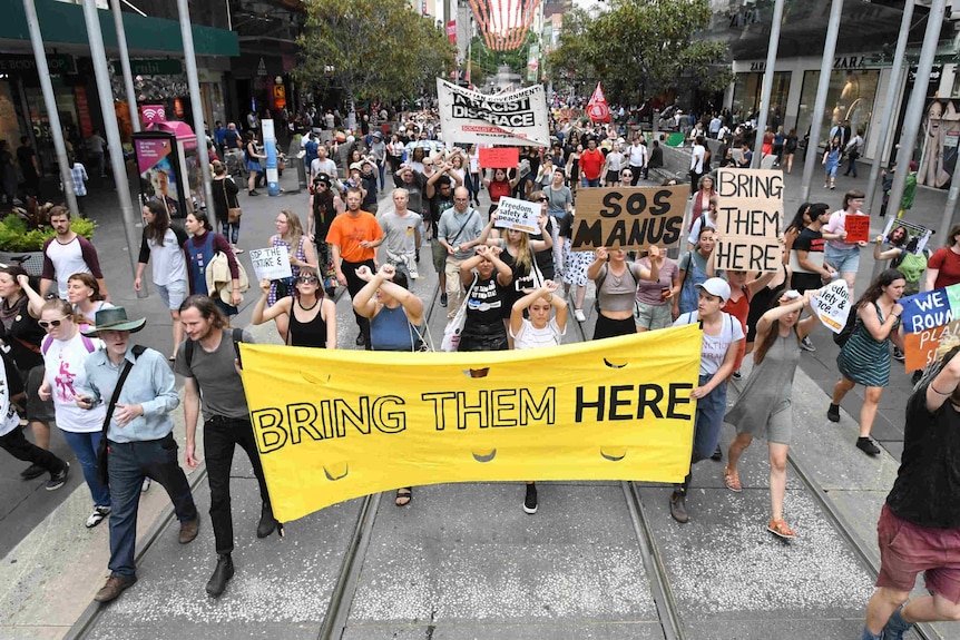 Group of protesters with sign saying "Bring them here".