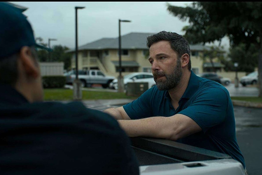 Ben Affleck leans on a car