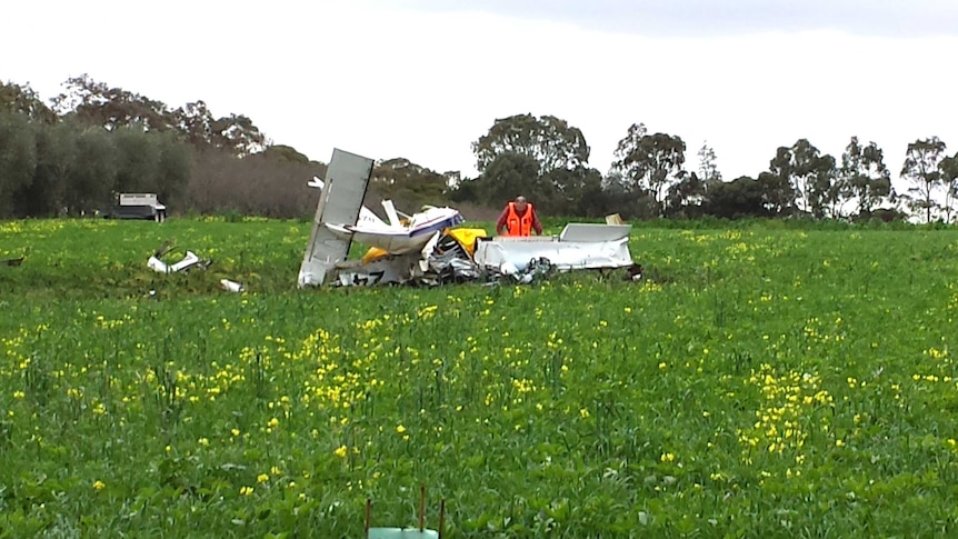 An investigator checks the wreckage after a light plane crashed into a Barossa Valley paddock. Two men died.