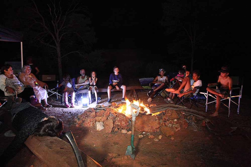 A group of Aboriginal people sitting round a campfire at night