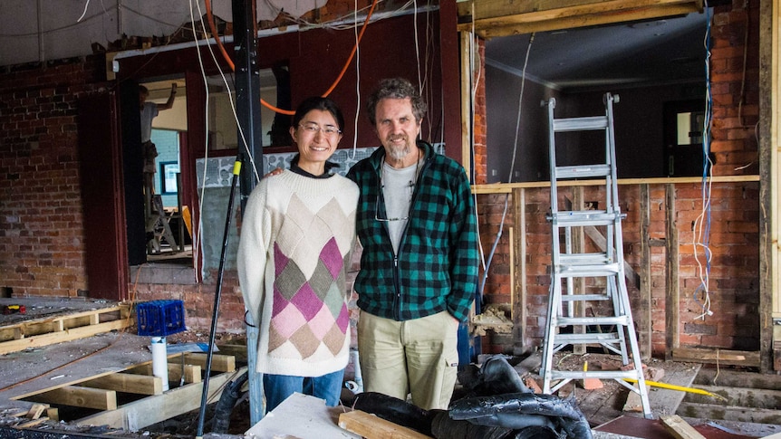 A man and a woman stand in a building site