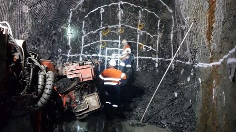 Two men working in an underground mine.