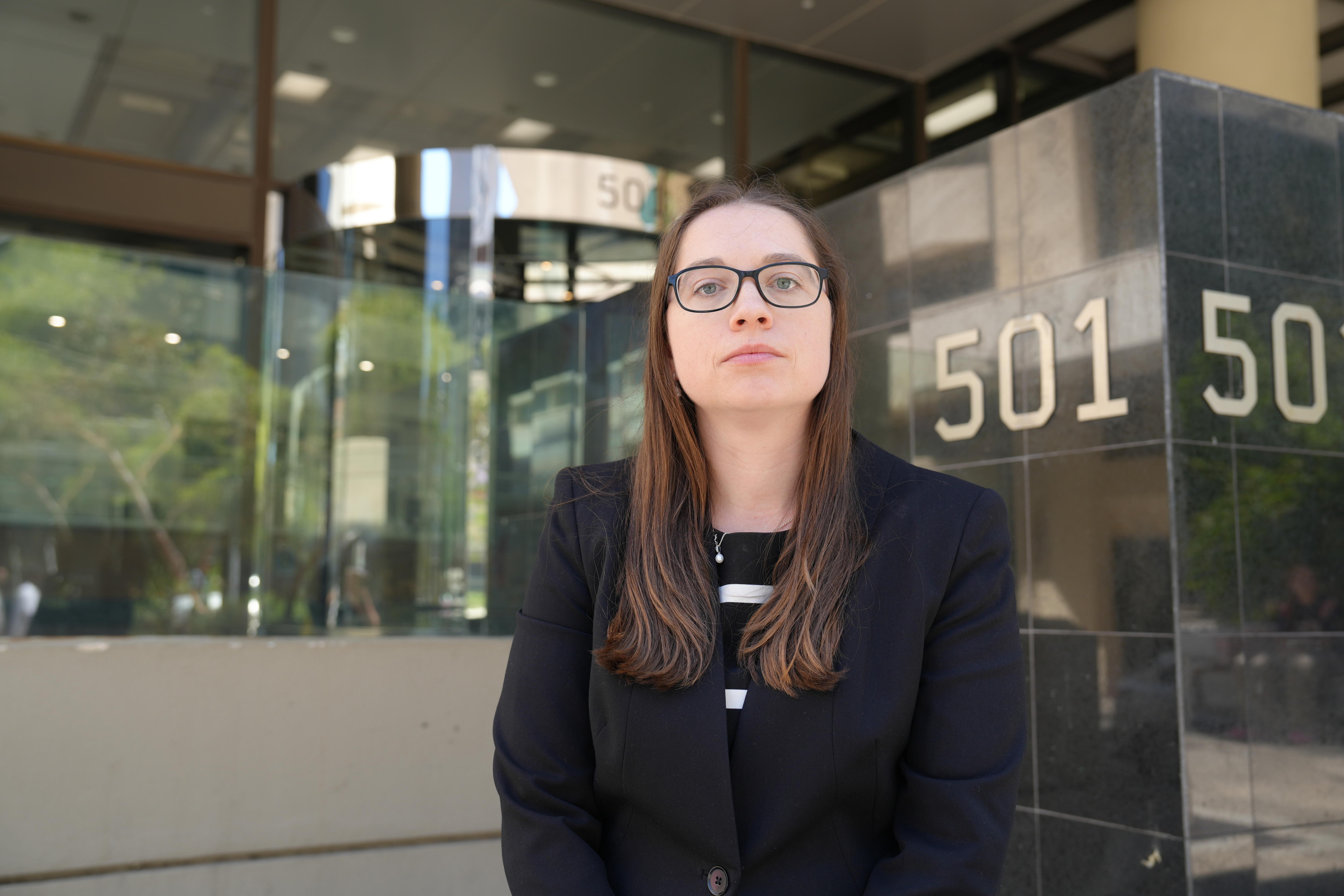 Karina Hawtrey usa anteojos y tiene una expresión seria en su rostro. 