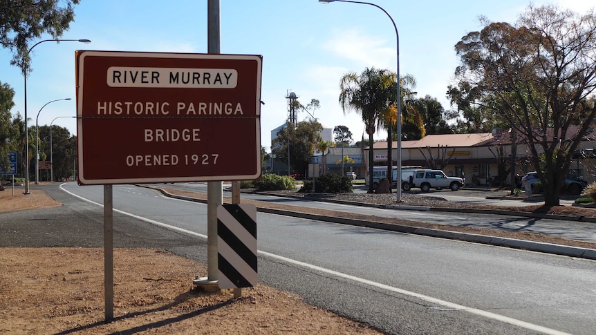 A sign with wording and a road