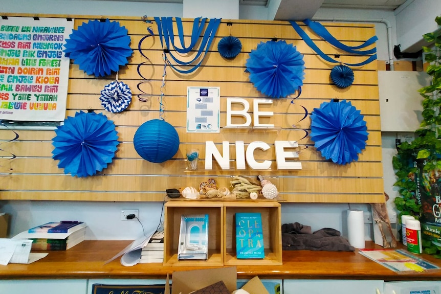An image of the letters 'BE NICE' and blue decorations around it.
