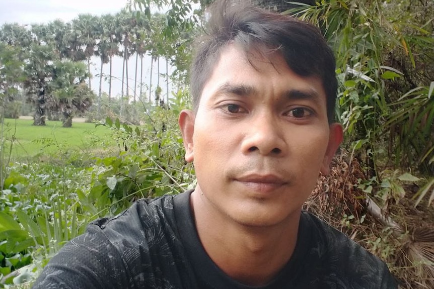 A young Cambodian man in a tropical garden