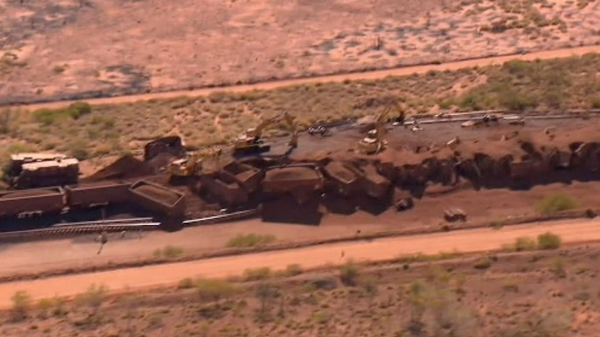 An aerial shot showing the wreckage of a deliberately derailed BHP iron ore train, with wagons lying strewn across the track.