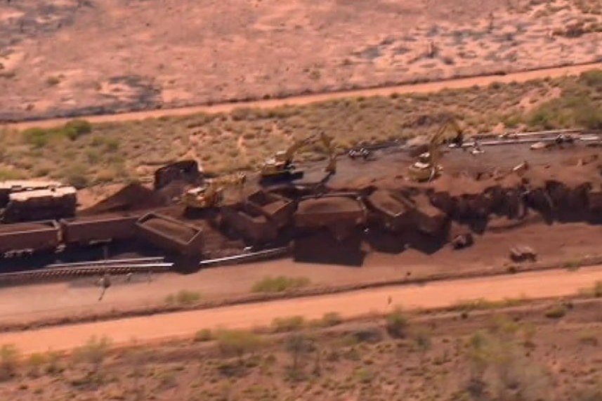 An aerial shot showing the wreckage of a deliberately derailed BHP iron ore train, with wagons lying strewn across the track.