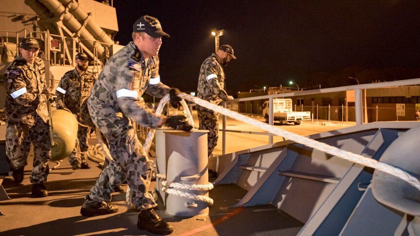 Sailors on board the Royal Australian Navy Frigate, HMAS Ballarat, prepare to set sail from dock in Perth.