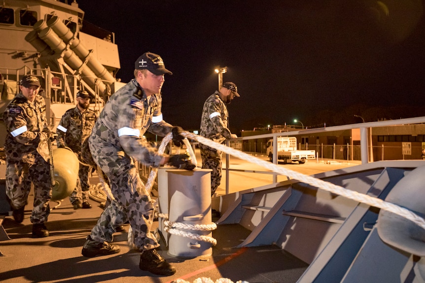 Sailors on board the Royal Australian Navy Frigate, HMAS Ballarat, prepare to set sail from dock in Perth.