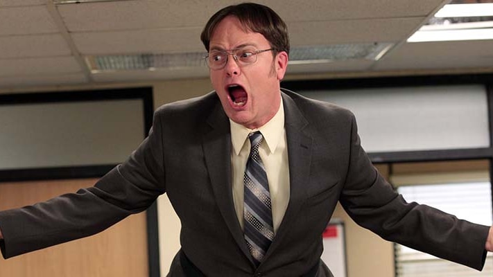 Dwight from The Office television show yells with a red face.