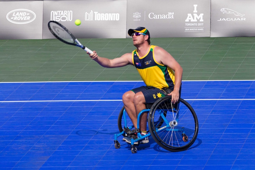 James in a wheelchair hitting a ball with a tennis racquet