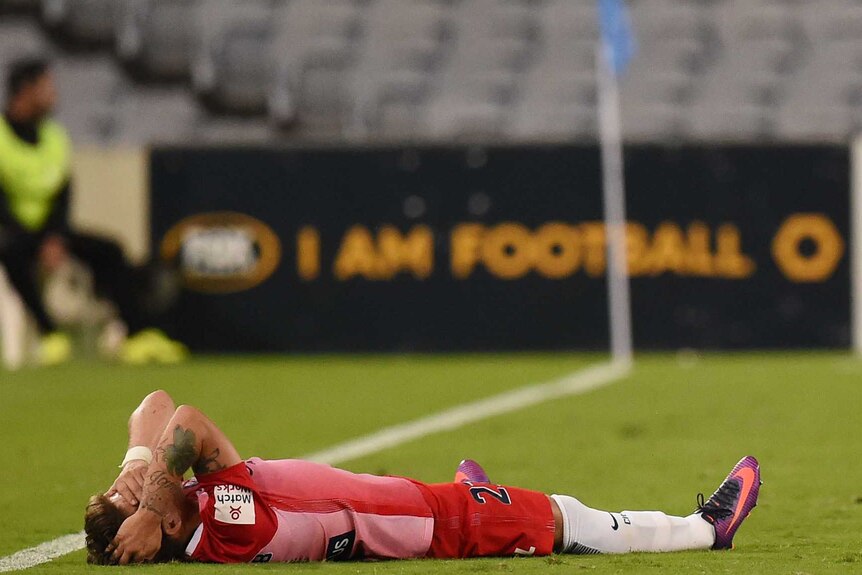 Fernando Brandan lays on the ground as Bernie Ibini scratches his head