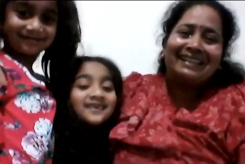three people smile during a video call
