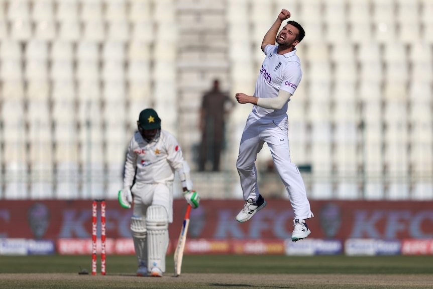 An English male Test cricketer jumps in the air and punches his right fist as he celebrates a wicket against Pakistan.