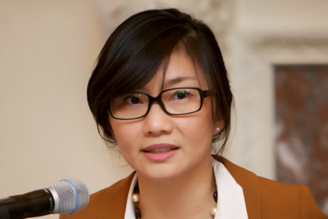 A woman speaks into a microphone