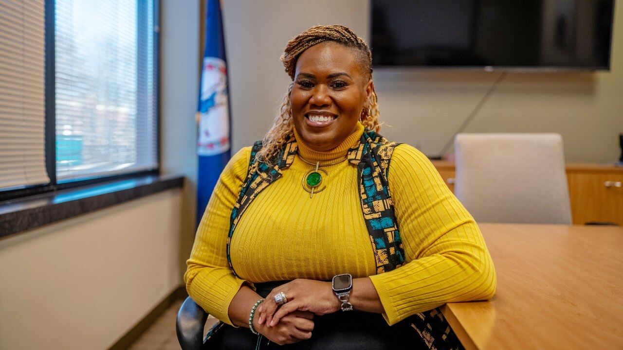 A woman sitting in a chair and smiling at the camera.