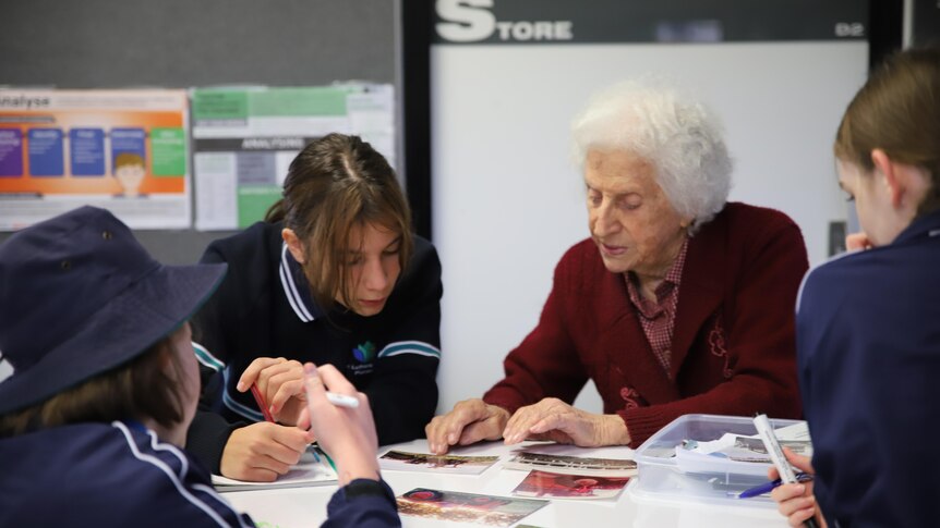 An elderly lady and a school student looking at school work together