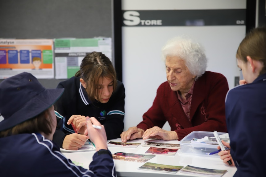 An elderly lady and a school student looking at school work together