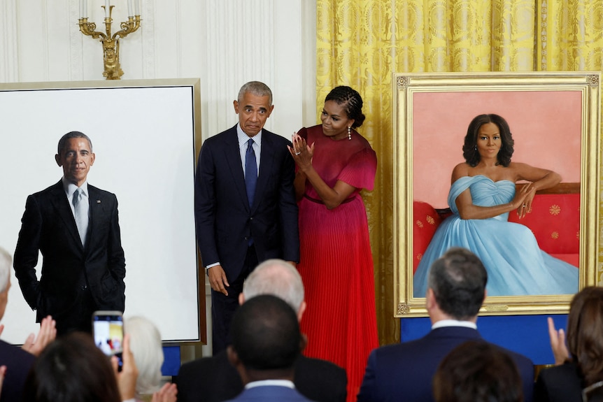 Barack and Michelle Obama stood between paintings of each other. 
