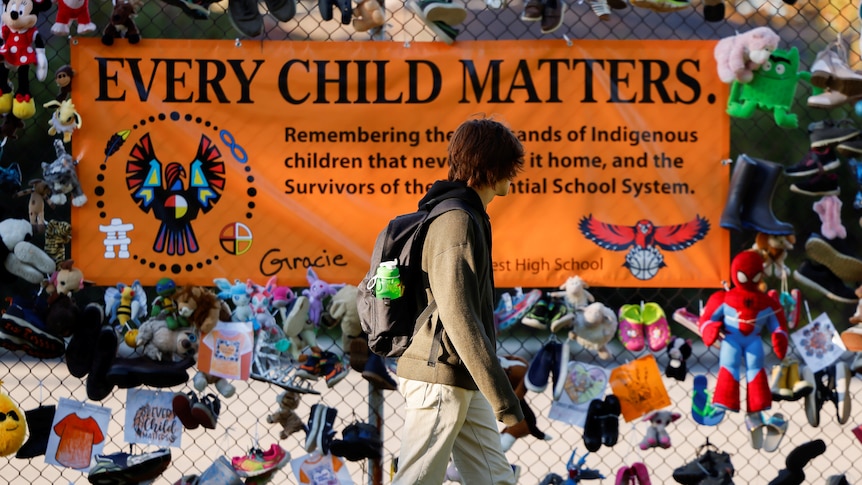 A man walks past a poster displaying the message 'every child matters' in Ontario, Canada, September 30 2021.