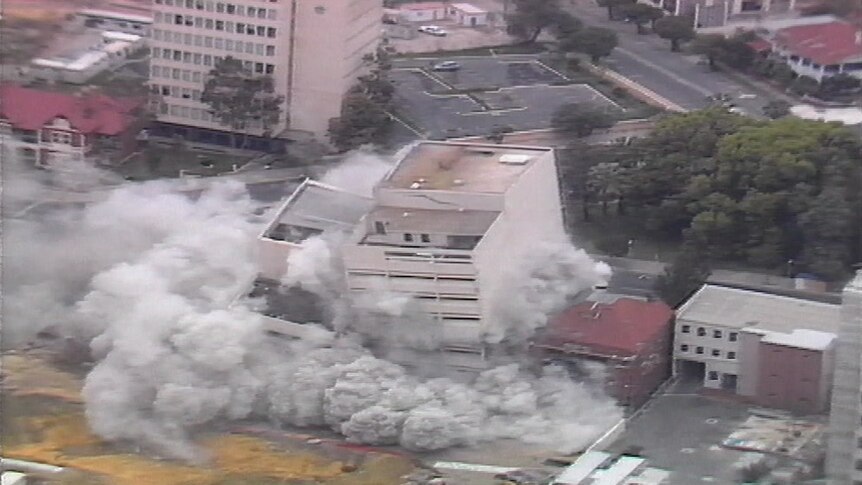 Two buildings being demolished with explosives