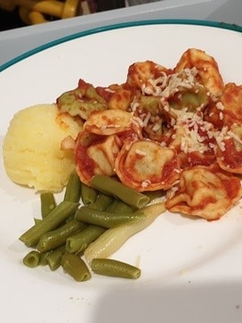 Pasta, frijoles y puré de patata en un plato.