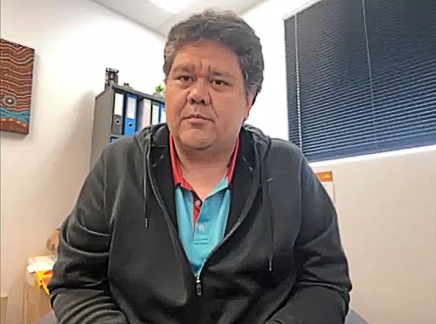 Kane Ellis sitting in an office, looking at the camera.