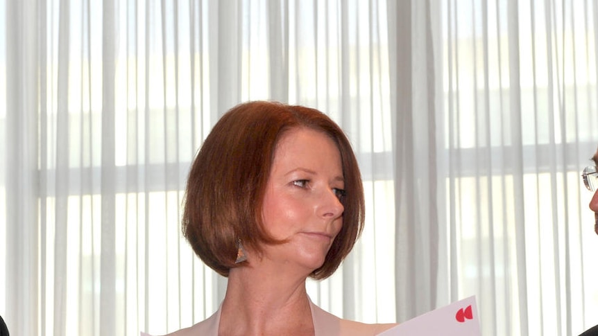 Julia Gillard receives the Critical Decade climate change report from Time Flannery and Will Steffen (AAP: Alan Porritt)