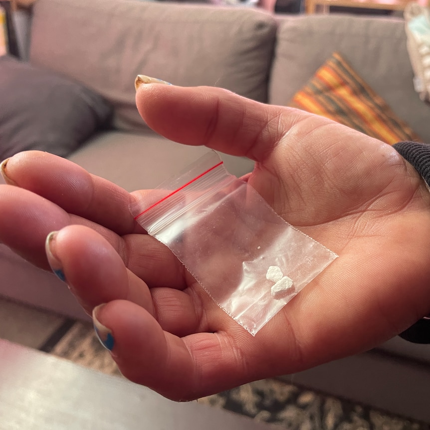 A bag of heroin in an unidentifiable hand.
