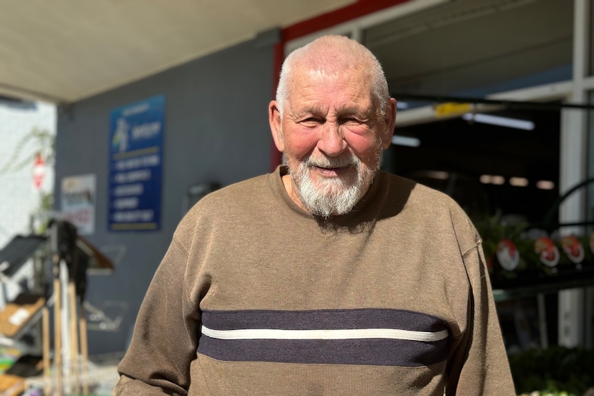 nanango man is smiling in a brown jumper and looking into the camera