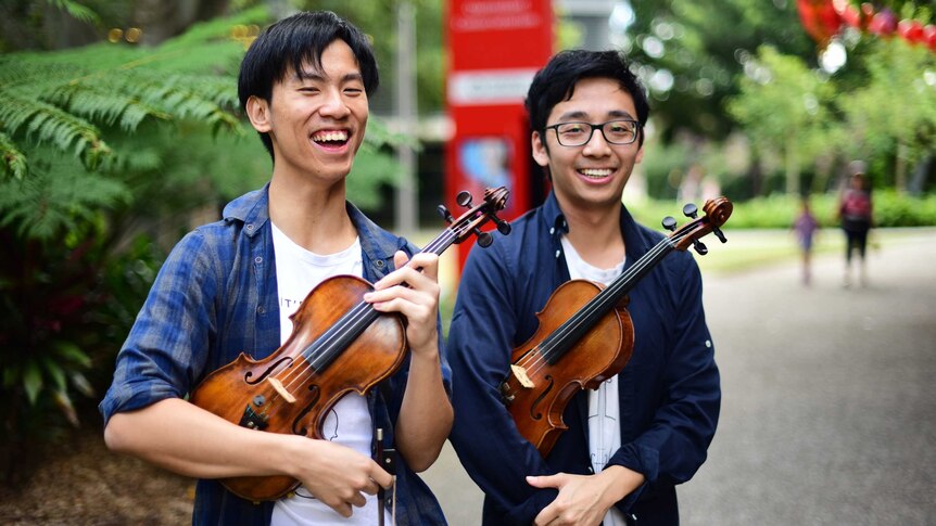 Eddy Chen (left) and Brett Yang holding violins in South Brisbane
