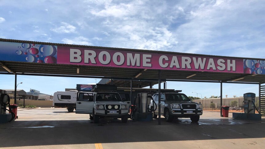 two cars go through a carwash marked Broome carwash