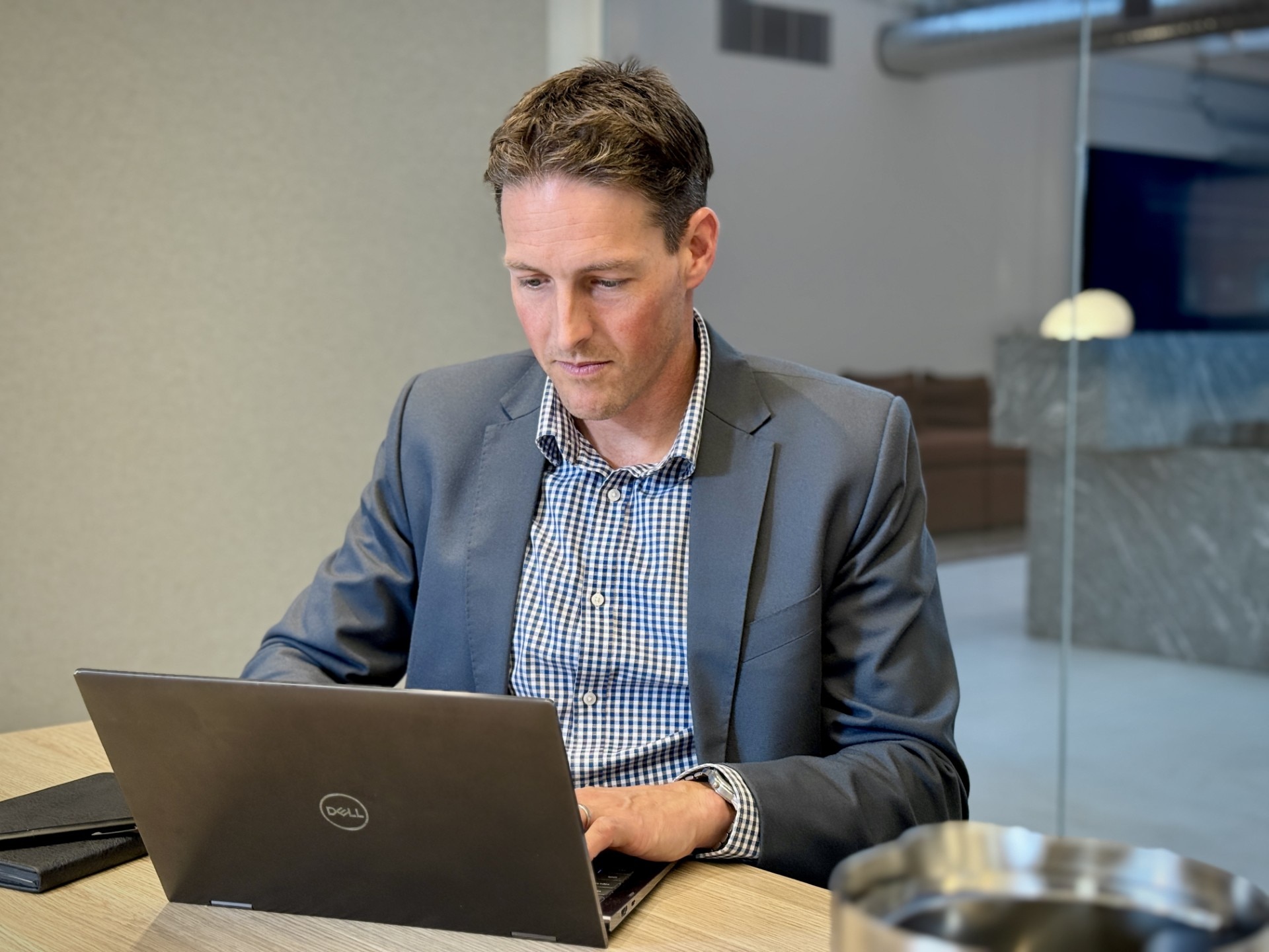 David Stribley sits at a desk looking at a laptop computer.