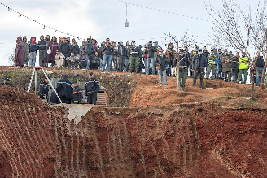 Residents watch as rescue workers try to save Moroccan boy in well