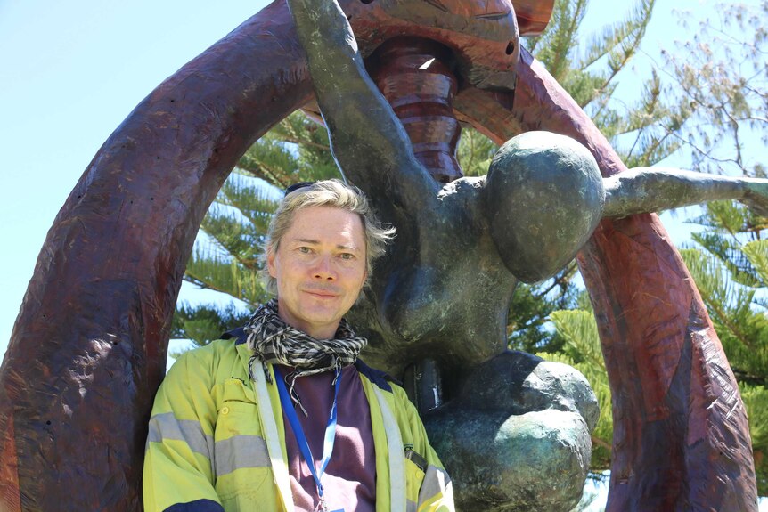 Toby Bell stands in front of his 700 kilogram sculpture, "The Cosmic Blacksmith".