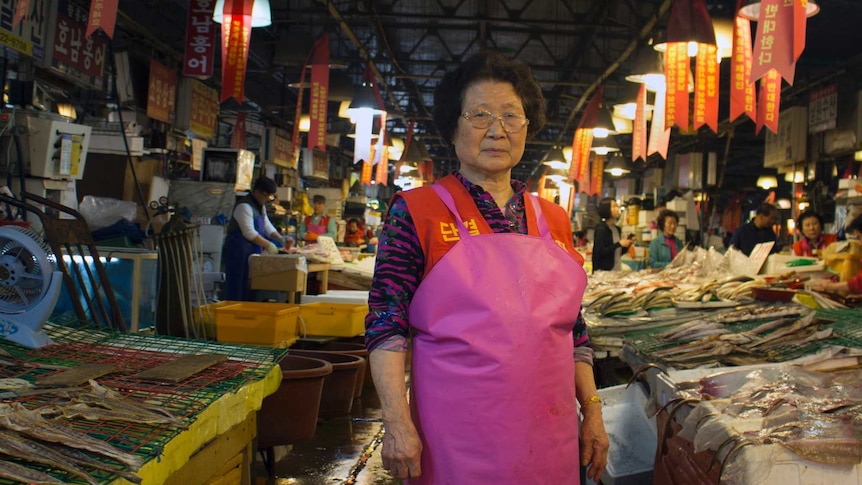 A vendor stands with her wares at Noryangjin fish market in Seoul