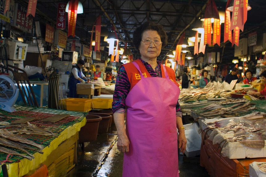 A vendor stands with her wares at Noryangjin fish market in Seoul
