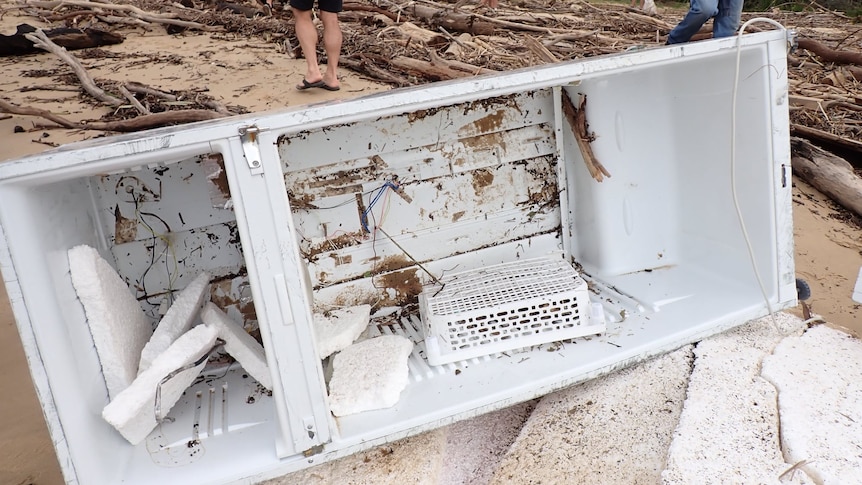 A dirty fridge on the banks of a river