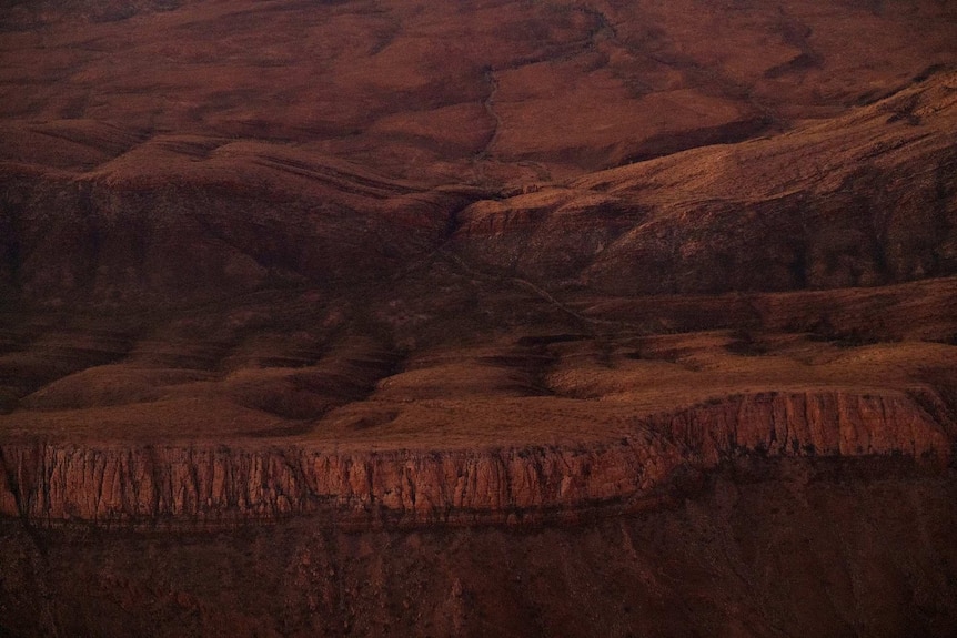 The Centipede Dreaming landscape between Haasts Bluff and Alice Springs shoes rolling desert hills.